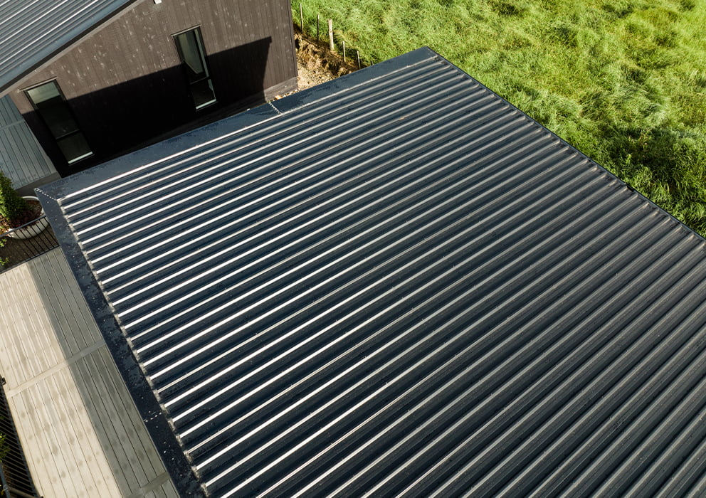 Black long run roofing on a commercial building in a building yard.