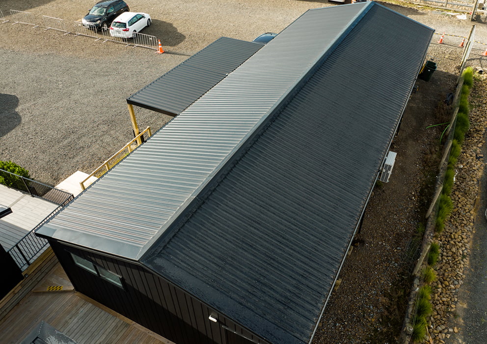 Black long run roofing on a new building in a development site.