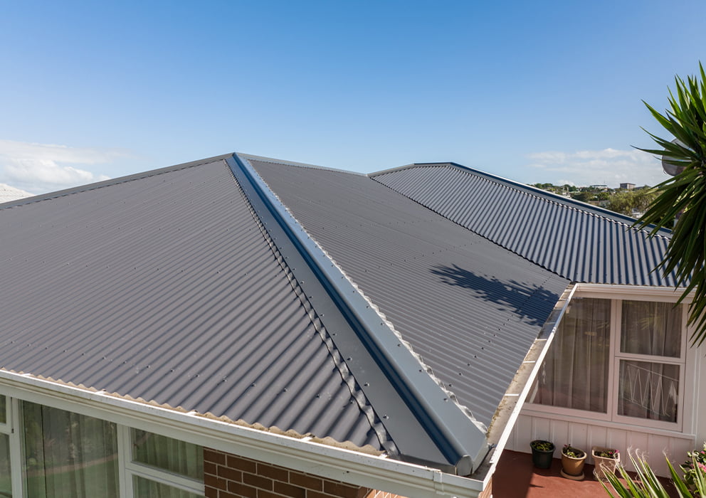 A grey long run roof replacement on a residential property.