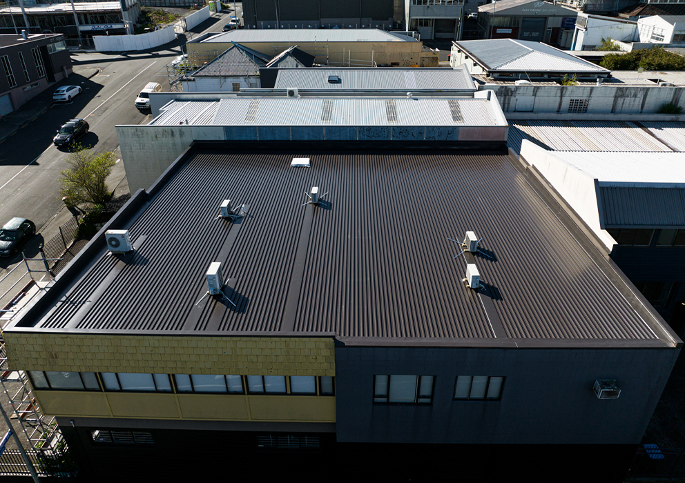 A commercial building with a black long run roof.