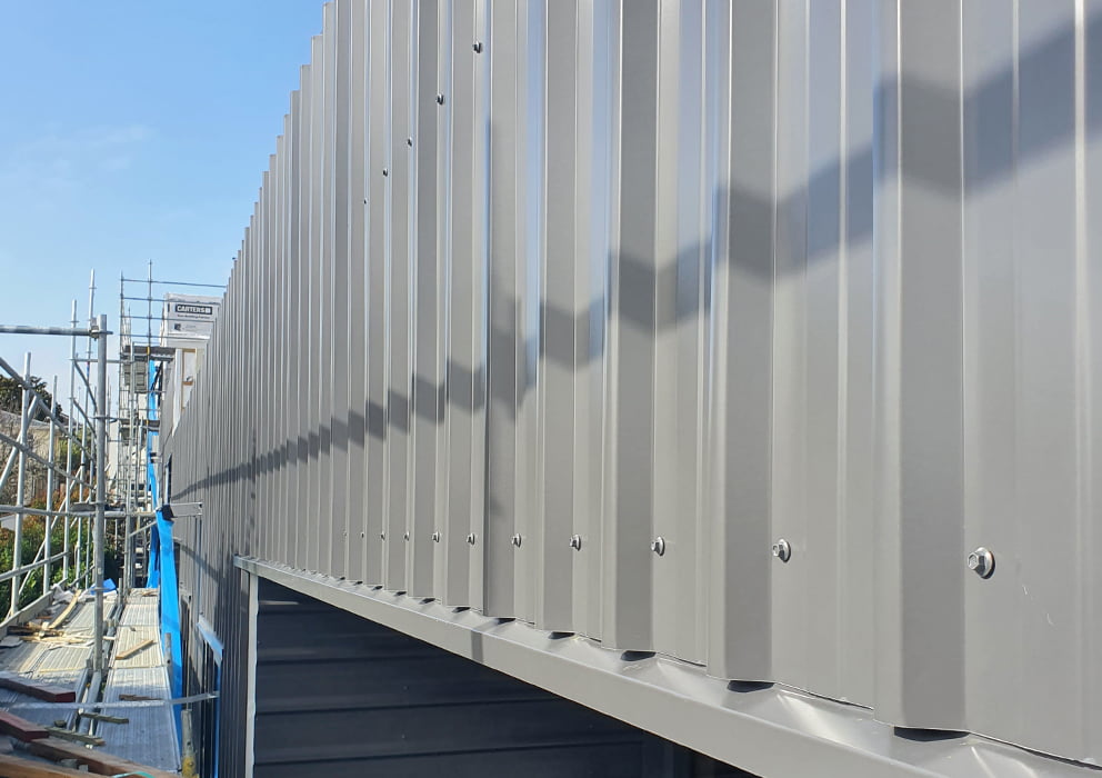 A close up image of grey steel cladding on a new build development.