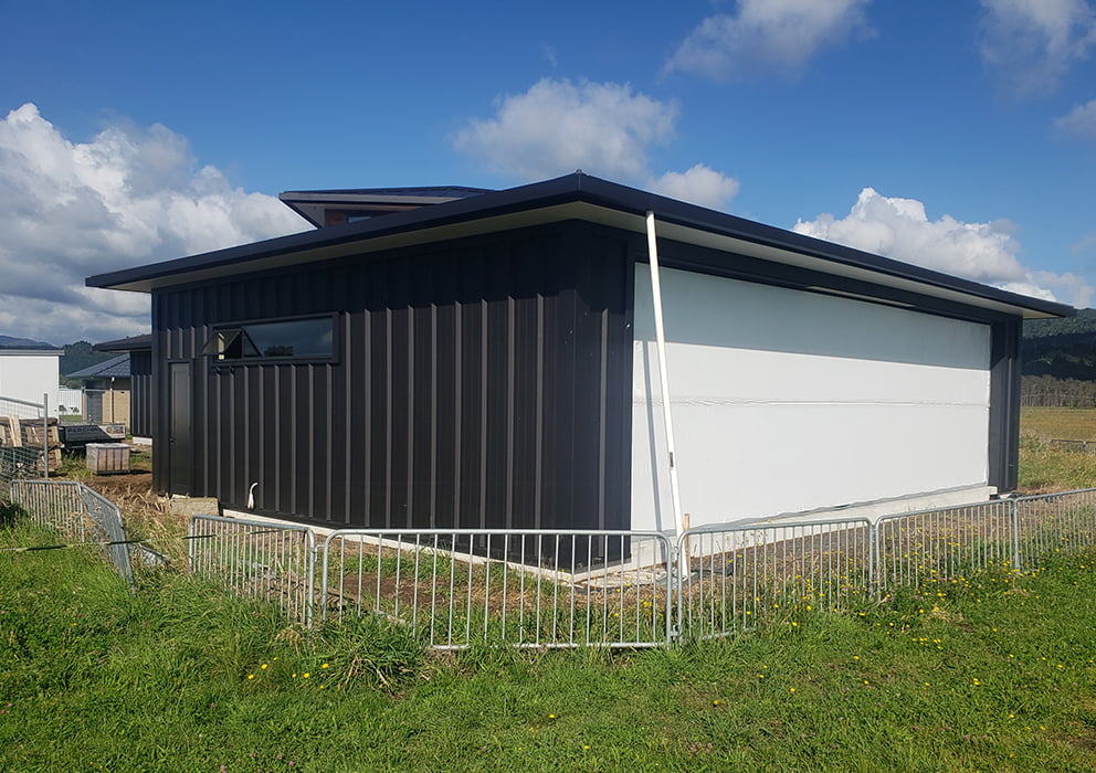 A new build with black cladding and long run roofing.