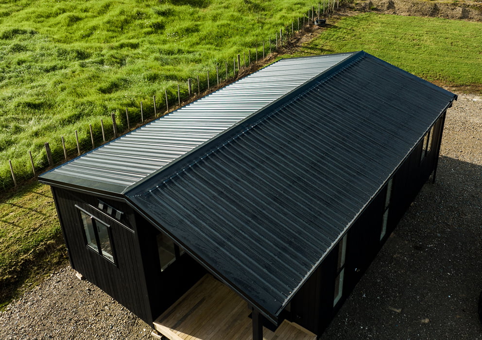 A black long run roof on a residential new build development.