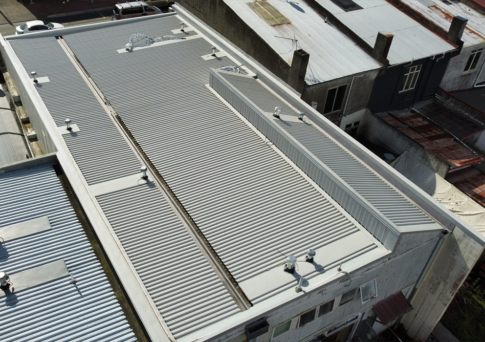 Photograph of a new light grey coloursteel roof on a commercial property.