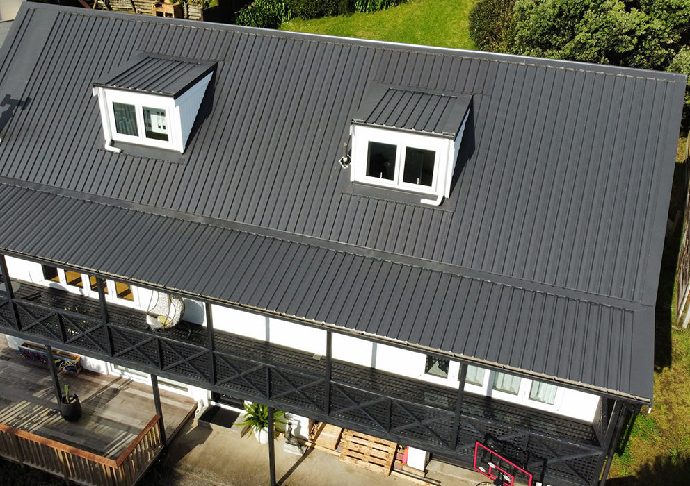 Photograph of a dark steel roof on a residential property.