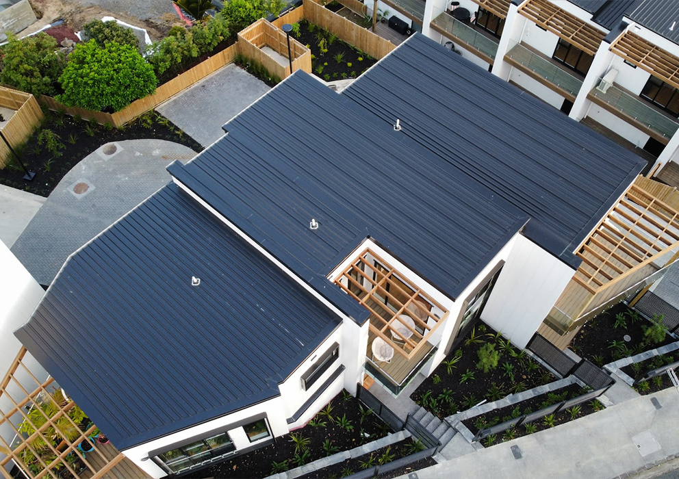 Aerial photograph of a new build apartment block with steel roofing.