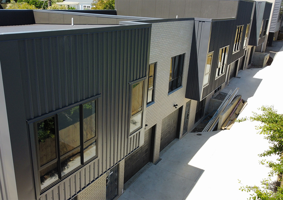Photo of townhouses with new roofing and cladding.