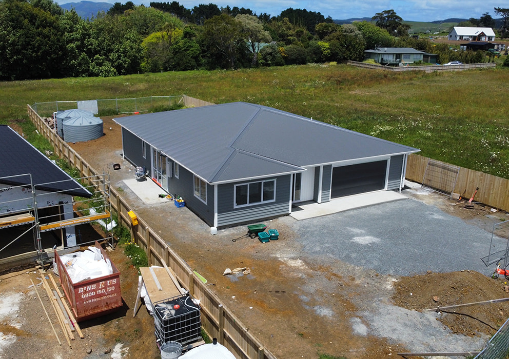 Photo of a new build residential home with steel roofing and guttering.