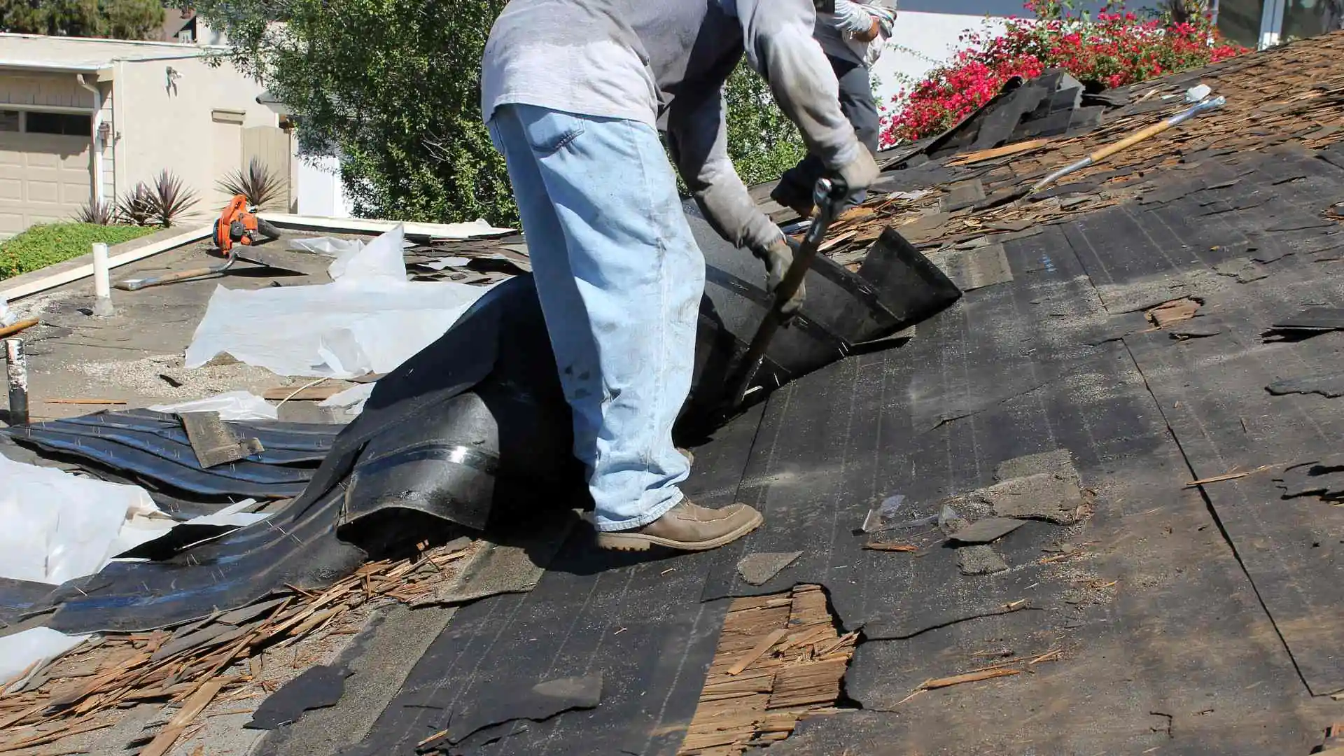 person pulling up an old roof