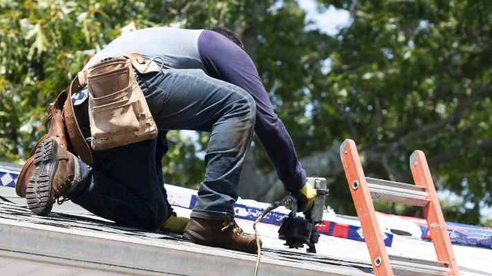 Worker performing an insurance-backed roof replacement